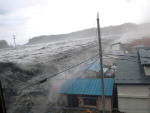 防潮堤を乗り越えて町に押し寄せる津波